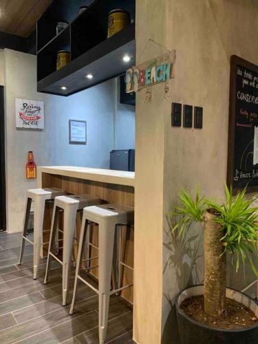 a bar with white stools in a restaurant at Spacious Beachfront Unit at Canyon Cove Nasugbu in Nasugbu