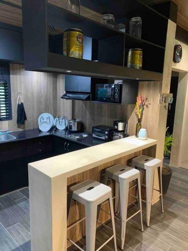 a kitchen with a counter and stools in it at Spacious Beachfront Unit at Canyon Cove Nasugbu in Nasugbu