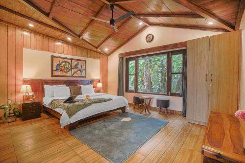 a bedroom with a bed and a large window at SaffronStays Zephyr in Nainital