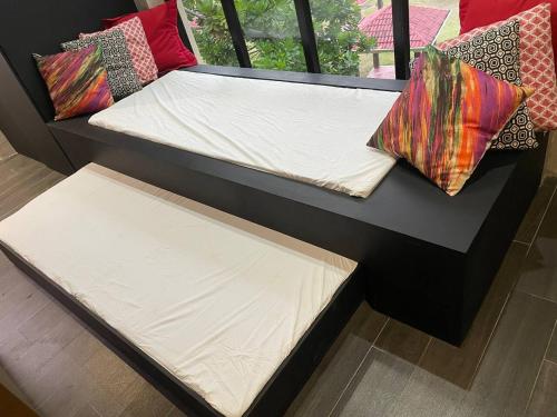 two beds in a room with pillows on them at Spacious Beachfront Unit at Canyon Cove Nasugbu in Nasugbu
