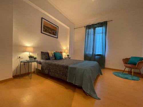 Cathedral Barcelona Rooms في برشلونة: غرفة نوم بسرير وستارة زرقاء