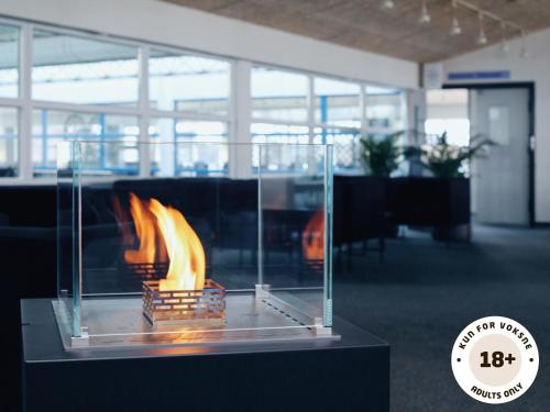 a fire in a glass case in an office at Ærø Hotel - Adults only in Marstal