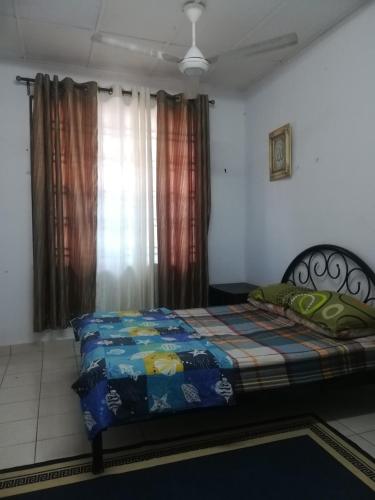 - une chambre avec un lit et une couverture colorée dans l'établissement Roomstay homestay Ahmad Rompin, à Kuala Rompin