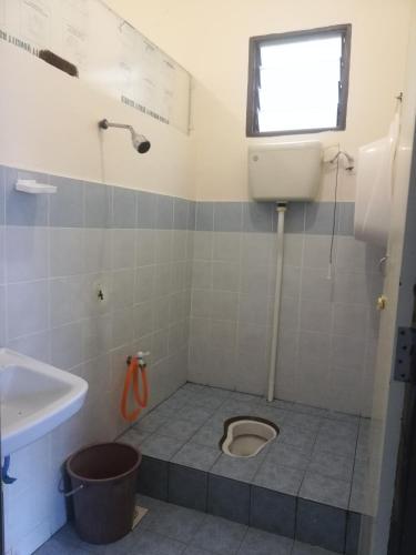 ein Bad mit einem WC und einem Waschbecken in der Unterkunft Roomstay homestay Ahmad Rompin in Kuala Rompin