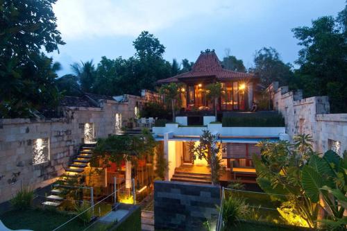 a house with stairs leading up to it at Villa Alcheringa Yogyakarta in Yogyakarta