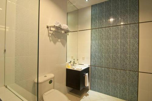 a bathroom with a shower and a toilet and a sink at Villa Alcheringa Yogyakarta in Yogyakarta