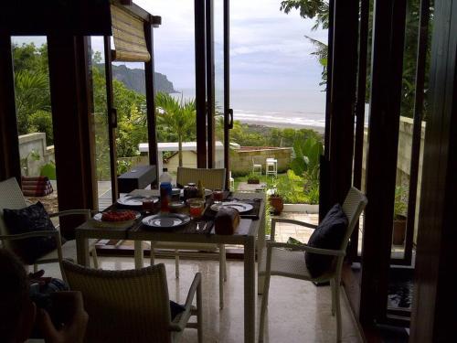 a table and chairs in front of a large window at Villa Alcheringa Yogyakarta in Yogyakarta