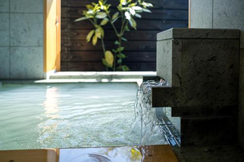 a water fountain in the middle of a pool at 宿坊　心月 in Arita