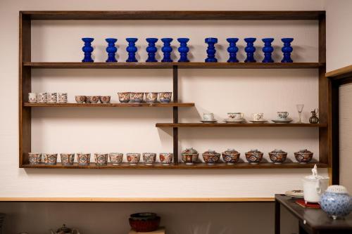 a shelf with blue vases and cups on it at 宿坊　心月 in Arita