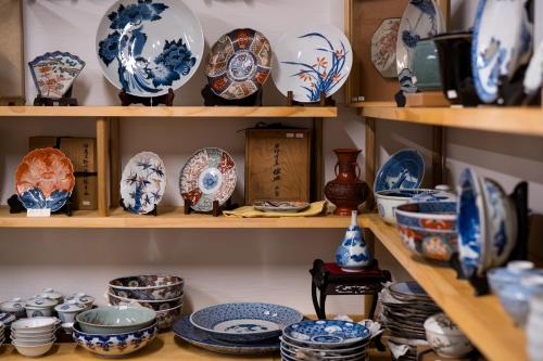 a shelf filled with blue and white plates and bowls at 宿坊　心月 in Arita
