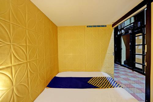 um pequeno quarto amarelo com uma cama em SPOT ON 92980 Luxury Capsule Homestay em Sidoarjo