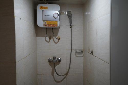 een badkamer met een douche en een telefoon aan de muur bij Collection O 92981 Apartemen The Jarrdin By Gold Suites Property in Bandung