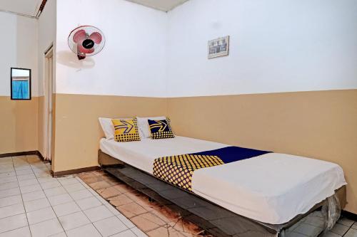 een slaapkamer met 2 bedden en een ventilator bij SPOT ON 92983 Hotel Ayu in Semarang