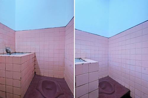 een roze betegelde badkamer met 2 urinoirs bij SPOT ON 92983 Hotel Ayu in Semarang