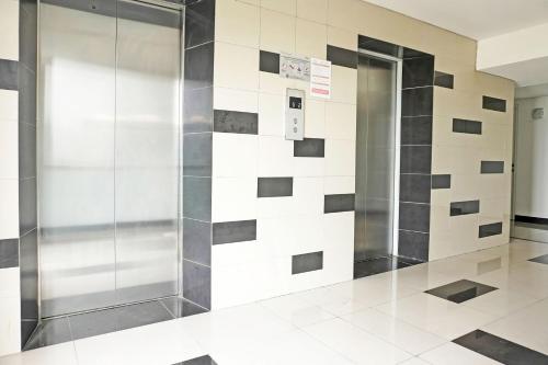 a elevator in a lobby with a tile wall at Collection O 92959 Apartement Sentraland Karawang By AT Room in Karawang