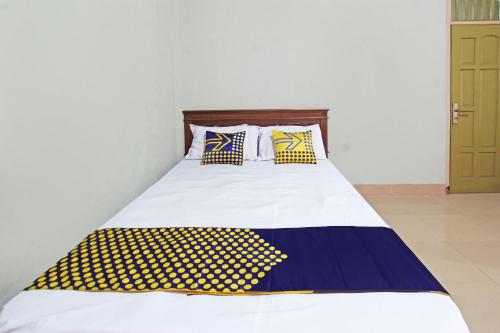 ロンボクにあるSPOT ON 92973 Madani Syariah Guesthouseのベッド(黄色と青色の枕付)