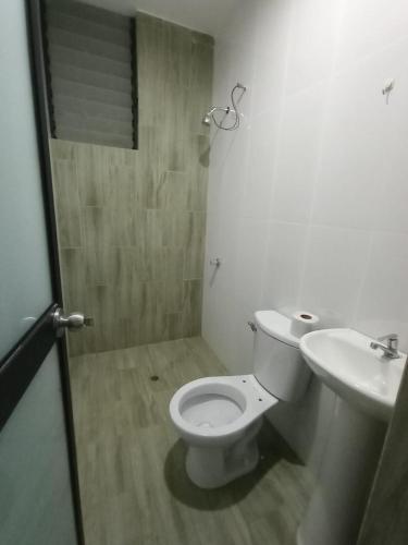 Łazienka z białą toaletą i umywalką w obiekcie DEPARTAMENTOS O'CALA w mieście Huánuco