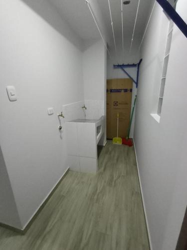 um quarto branco com um lavatório e um piso em DEPARTAMENTOS O'CALA em Huánuco