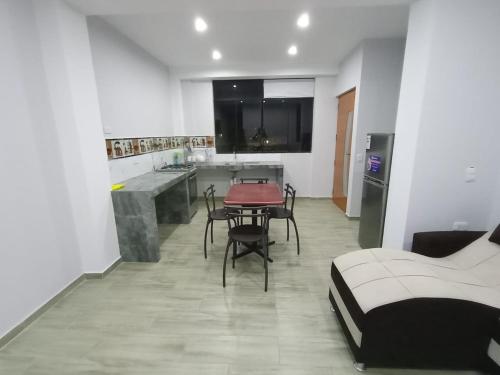 Zimmer mit einer Küche, einem Tisch und einem Bett in der Unterkunft DEPARTAMENTOS O'CALA in Huánuco