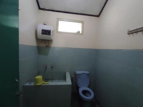 a bathroom with a toilet and a sink and a window at OYO 93048 Hotel Puri Mandiri in Purworejo