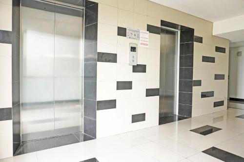 a elevator in a lobby with a tile wall at Collection O 92967 Apartement Sentraland Karawang By Rda Living in Jaken 1