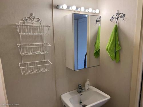 uma casa de banho com um lavatório e um espelho em Ihana huoneisto meren lähellä. em Helsinque
