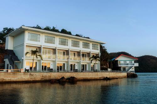 duży biały budynek na doku na wodzie w obiekcie Coron Underwater Garden Resort w mieście Coron