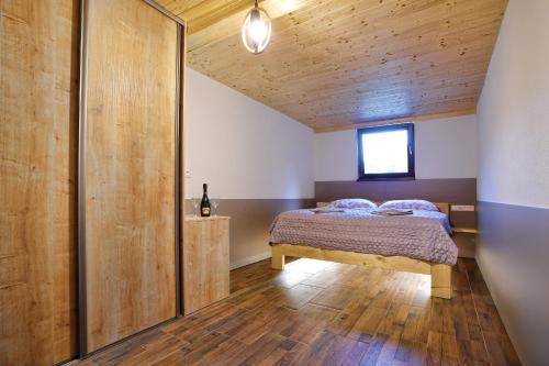 ein Schlafzimmer mit einem Bett und einer Holzwand in der Unterkunft Chalet Dereše in Liptovský Mikuláš