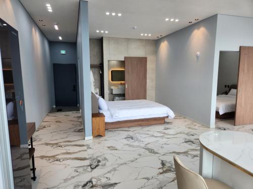 a bedroom with a bed and a marble floor at Suite Stay Yeosu in Yeosu