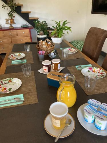 a wooden table with plates and cups on it at La Gelette in Génissac