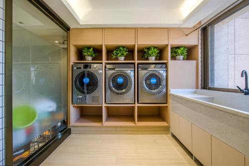 uma lavandaria com duas lavagens e vasos de plantas em Yiwu Baide Theme Hotel em Yiwu