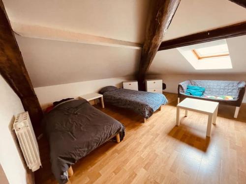 a attic bedroom with two beds and a window at L'edelweiss: three-bedroom hypercentre in Saint-Étienne