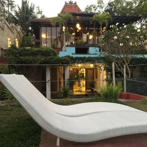 a white bench in front of a house at Villa Alcheringa Yogyakarta in Yogyakarta