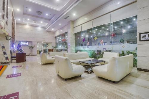 a lobby with white furniture and a table and chairs at Palette - Hotel chennai le palace in Chennai