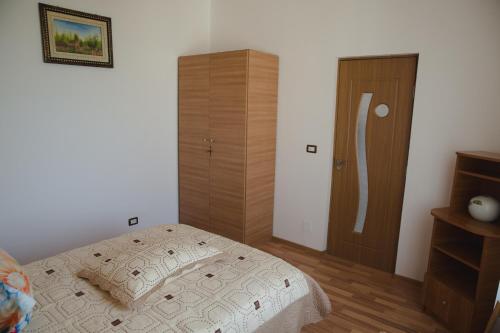a bedroom with a bed and a wooden door at Casa Rustica in Focşani