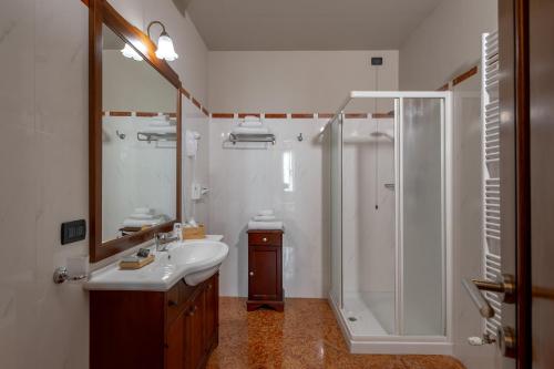 a white bathroom with a shower and a sink at Hotel Antica Dimora in Mantova