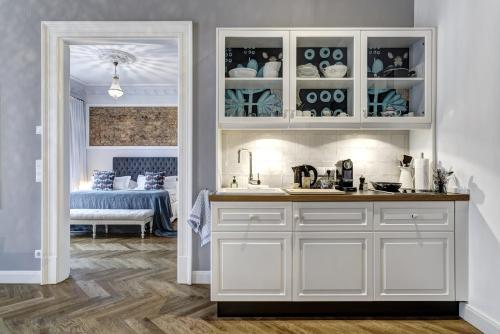 a kitchen with white cabinets and a room with a bed at Gorki Apartments in Berlin