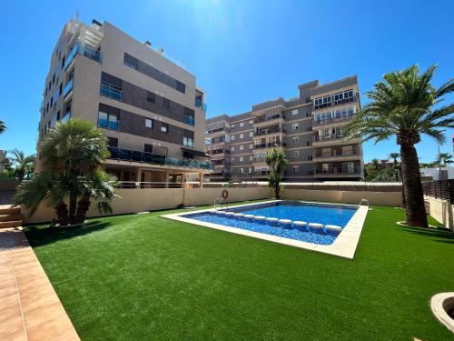 a large yard with a swimming pool and palm trees at Mirador dels Terrers in Benicàssim