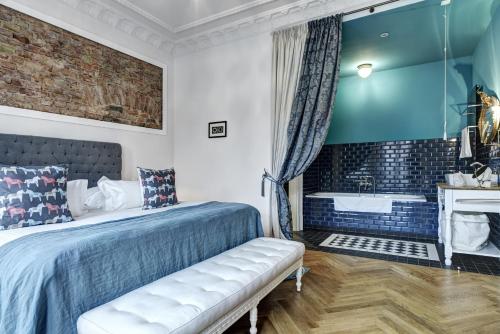 a bedroom with a bed and a tub and a sink at Gorki Apartments in Berlin