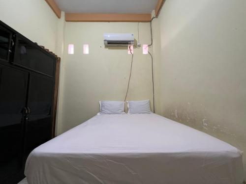 a small bedroom with a white bed in it at OYO 93053 Ziza Kost82 Syariah 