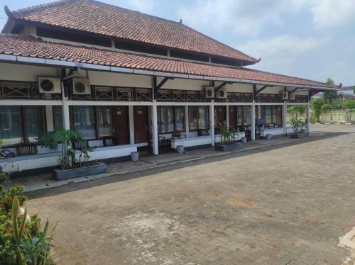 a building with white benches in front of it at Capital O 93024 Hotel Ganesha in Purworejo