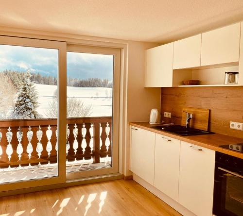 a kitchen with a large window with a view at Gästehaus Steiert Fewo Kuhbergblick in Lenzkirch