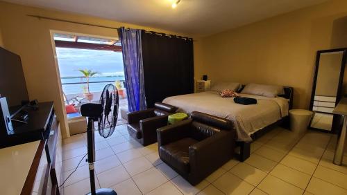 a bedroom with a bed and a chair and a window at L'Horizon in Bora Bora