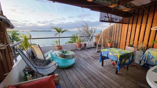 einen Balkon mit einem Tisch und Stühlen sowie Blick auf das Wasser in der Unterkunft L'Horizon in Bora Bora