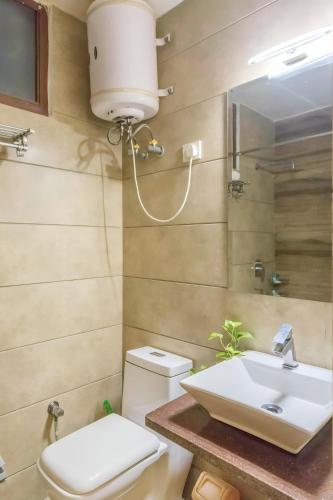 a bathroom with a sink and a toilet at Woodpecker Apartments Hauz khas in New Delhi