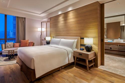 a hotel room with a large bed and a desk at DoubleTree by Hilton Shanwei in Shanwei