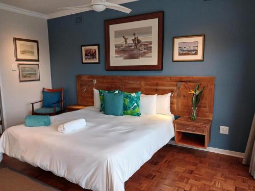 a bedroom with a large bed with blue walls at Ocean Gaze Bed and Breakfast in Ramsgate