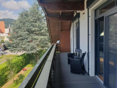 een balkon met zwarte stoelen op een huis bij Luxury - Loft in Villach