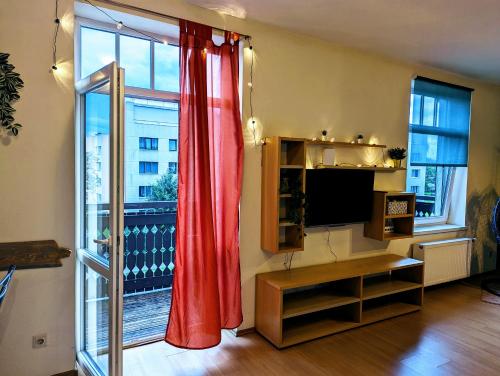 斯伽爾達的住宿－Little Cozy Place，客厅配有红色窗帘和大窗户