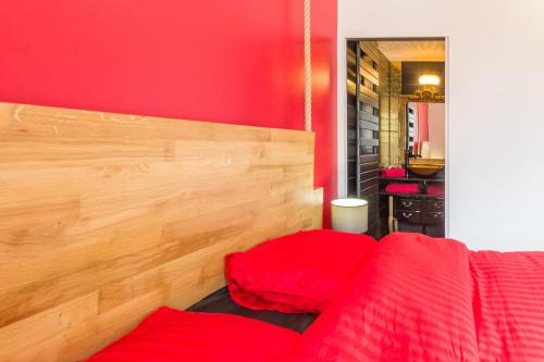 a red room with a bed and a red wall at L'Escale de Jules et Lily in Bligny-lès-Beaune